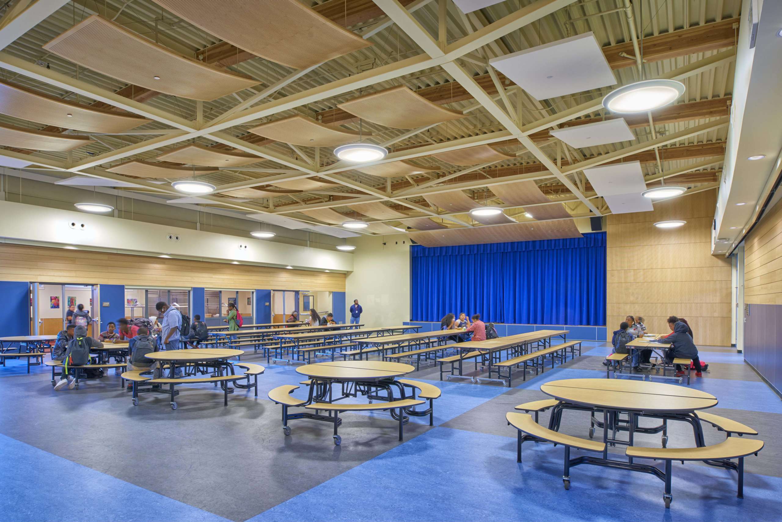 Large auditorium space with tables and chairs at Korematsu School
